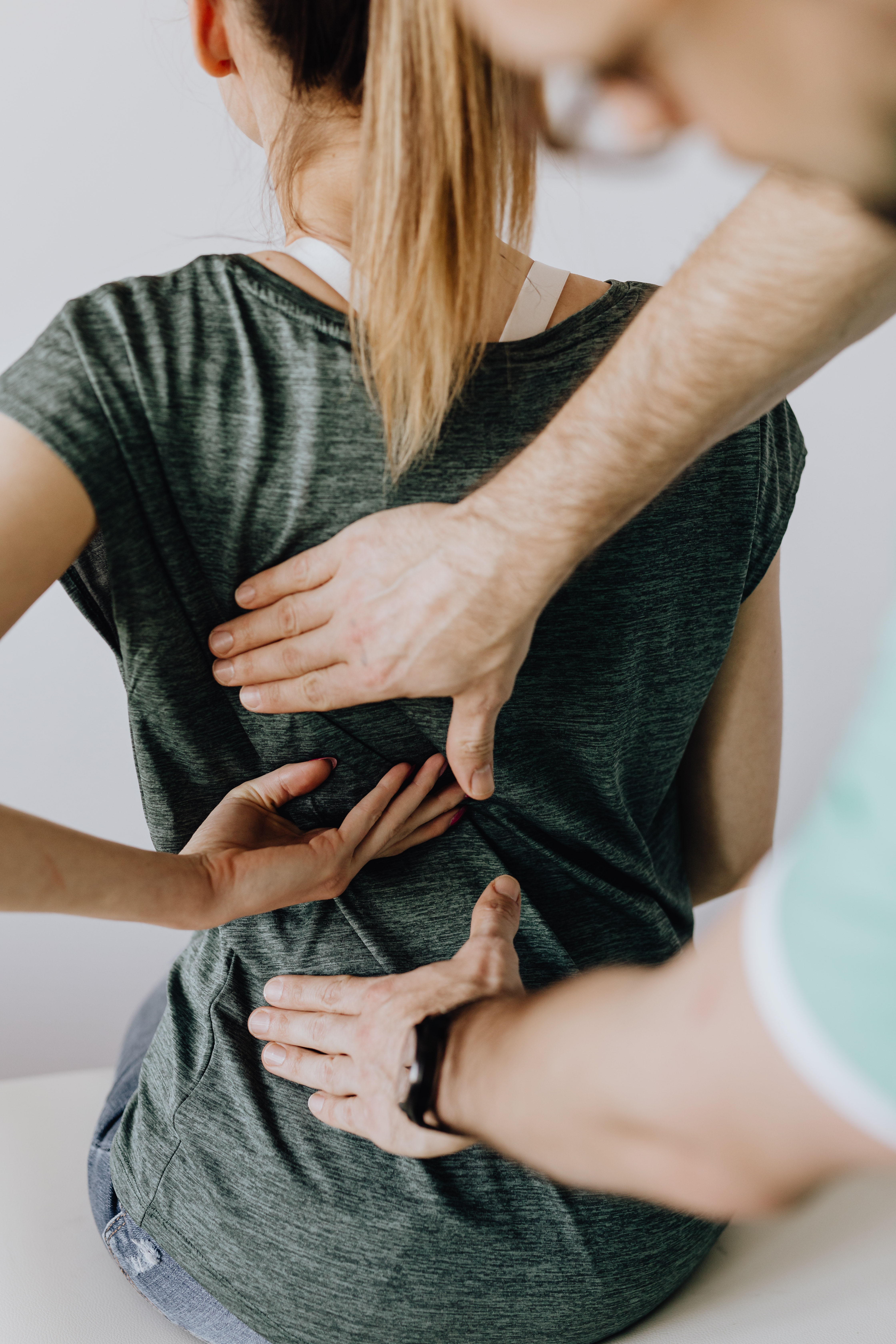 Arzt untersucht Rücken einer Patientin
