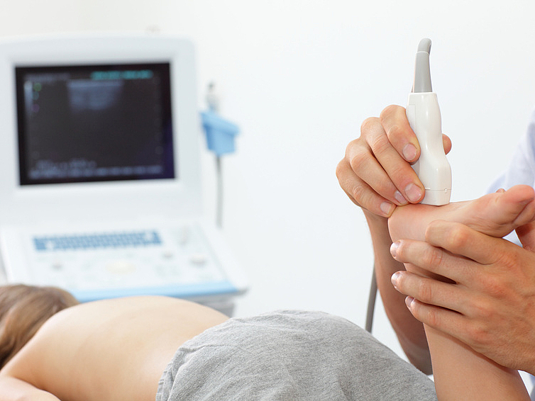 Sonographie bei Kindern Arzt untersucht Ferse eines Kindes