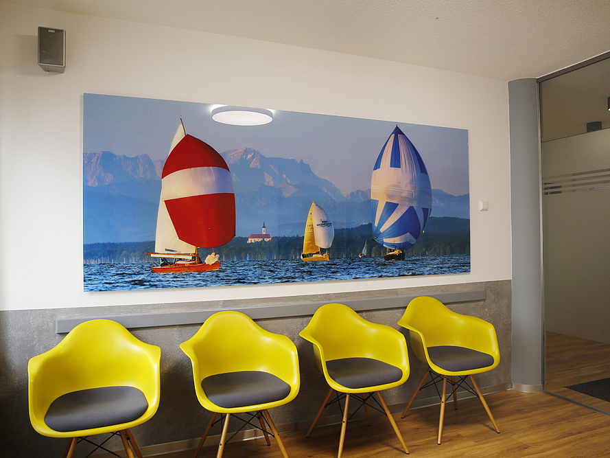 Ein Wartezimmer mit gelben Stühlen im Orthozentrum Miesbach.